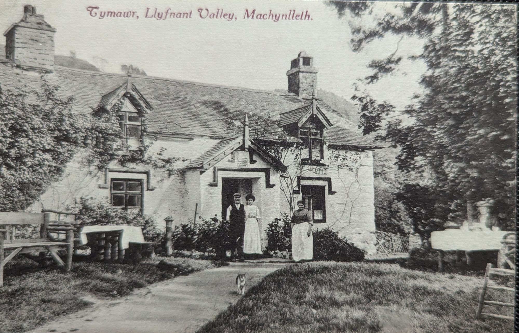 Historic postcard view of Tymawr in the Llyfnant Valley near Machynlleth, with three people standing outside